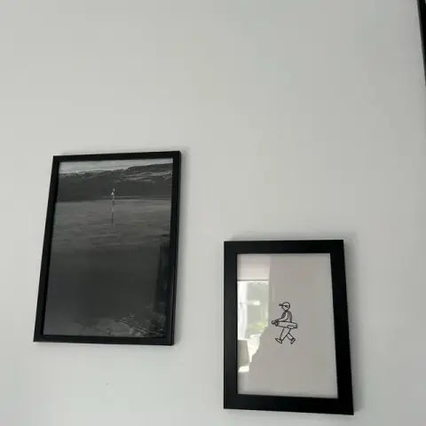 Two framed prints on a white wall in Robert's home office