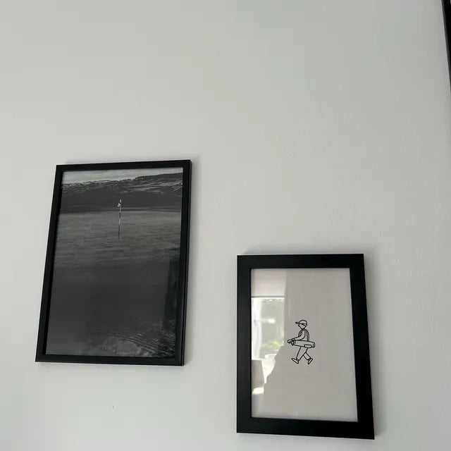 Two framed prints on a white wall in Robert's home office