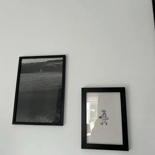Two framed prints on a white wall in Robert's home office