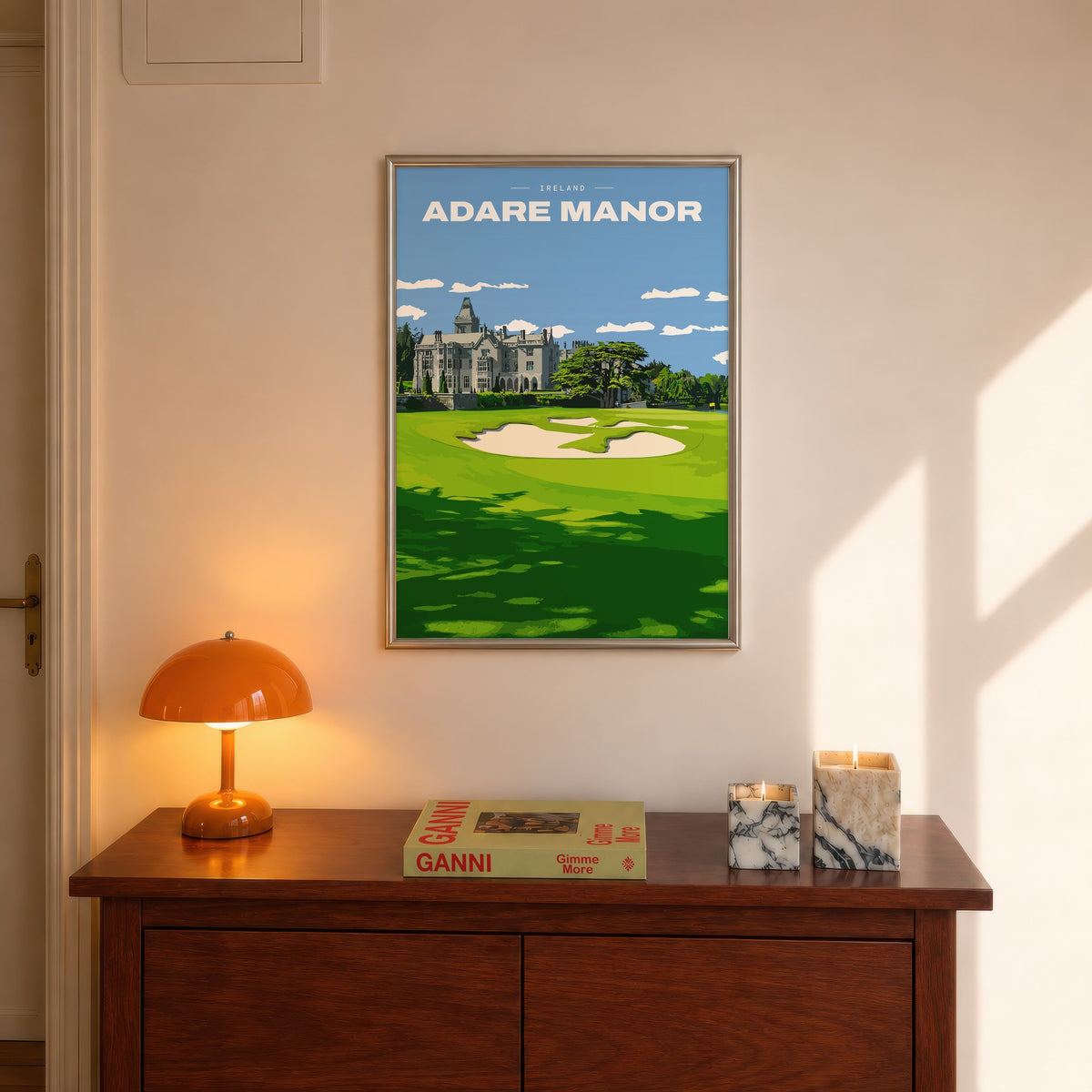 Adare Manor golf print of the manor house behind a green and bunkers, framed above a console beside an orange lamp