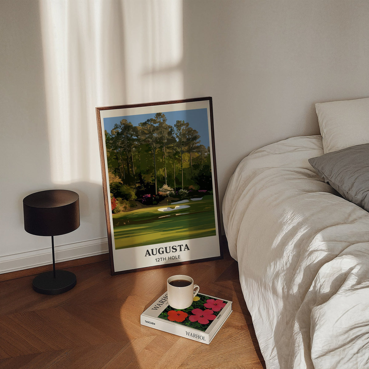 Augusta 12th hole golf print of a par 3 green below azaleas, cream border, framed, leaning by a bed