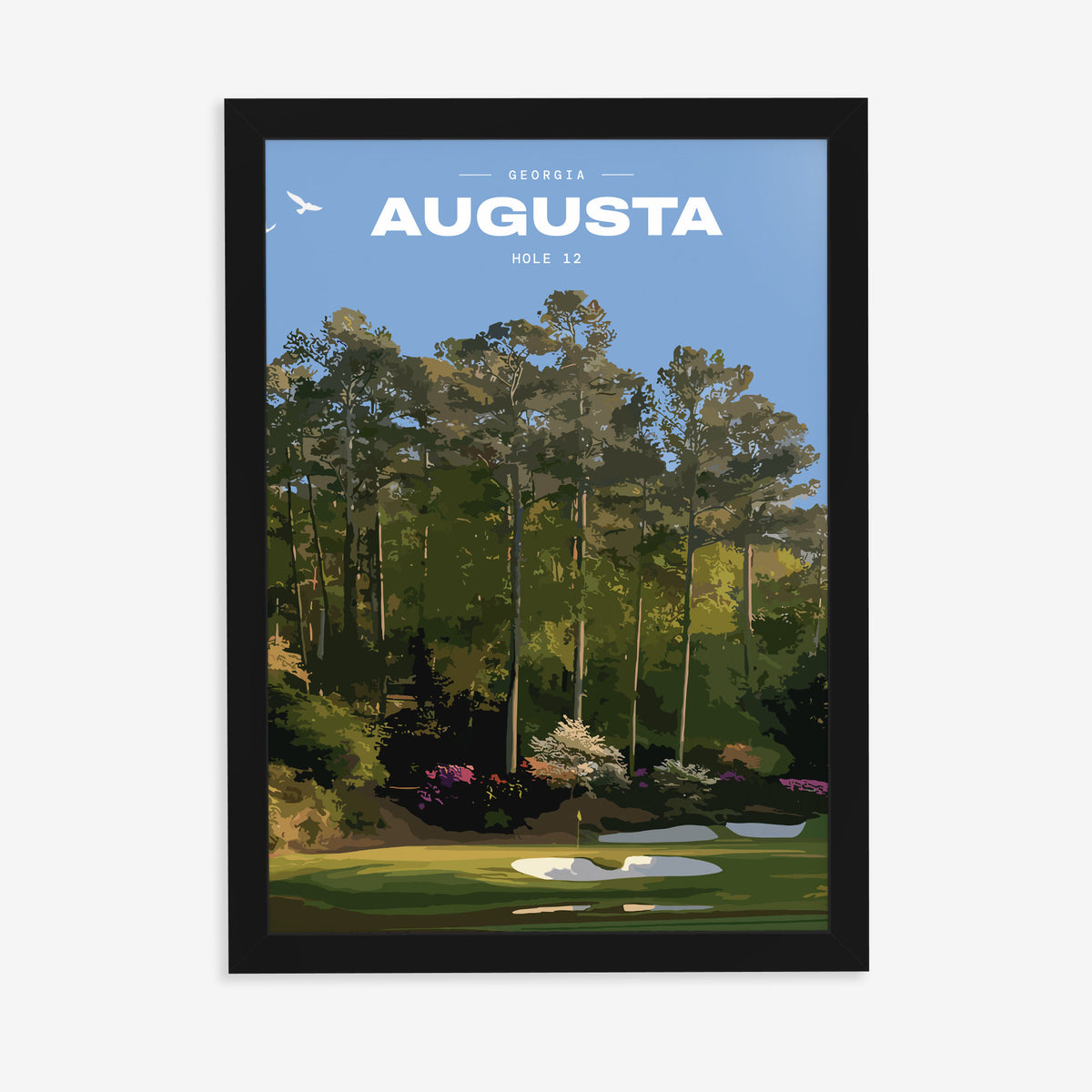 Augusta 12th hole golf print of a par 3 green below azaleas and pines, in a black frame on a plain wall