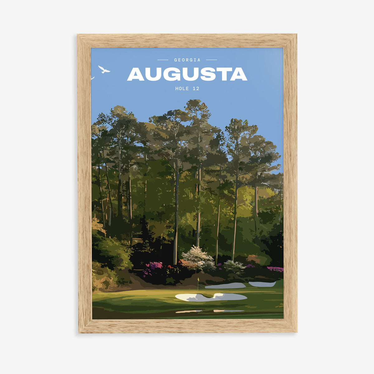 Augusta 12th hole golf print of a par 3 green below azaleas and pines, in a natural wood frame on a plain wall