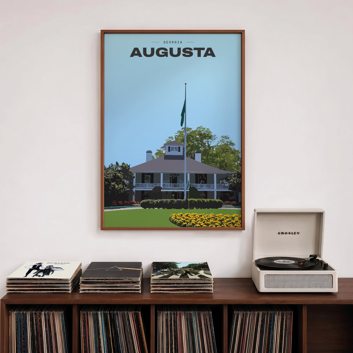 Augusta The Clubhouse golf print of the white clubhouse and yellow flowers, framed above a record shelf beside a turntable