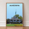 Augusta The Clubhouse golf print of the white clubhouse and yellow flowers, in an oak frame, leaning against a wall on a herringbone floor