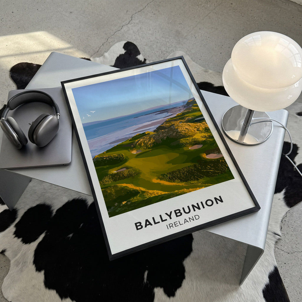 Ballybunion golf print of links greens above the sea, cream border, framed, lying on a steel table on a cowhide rug