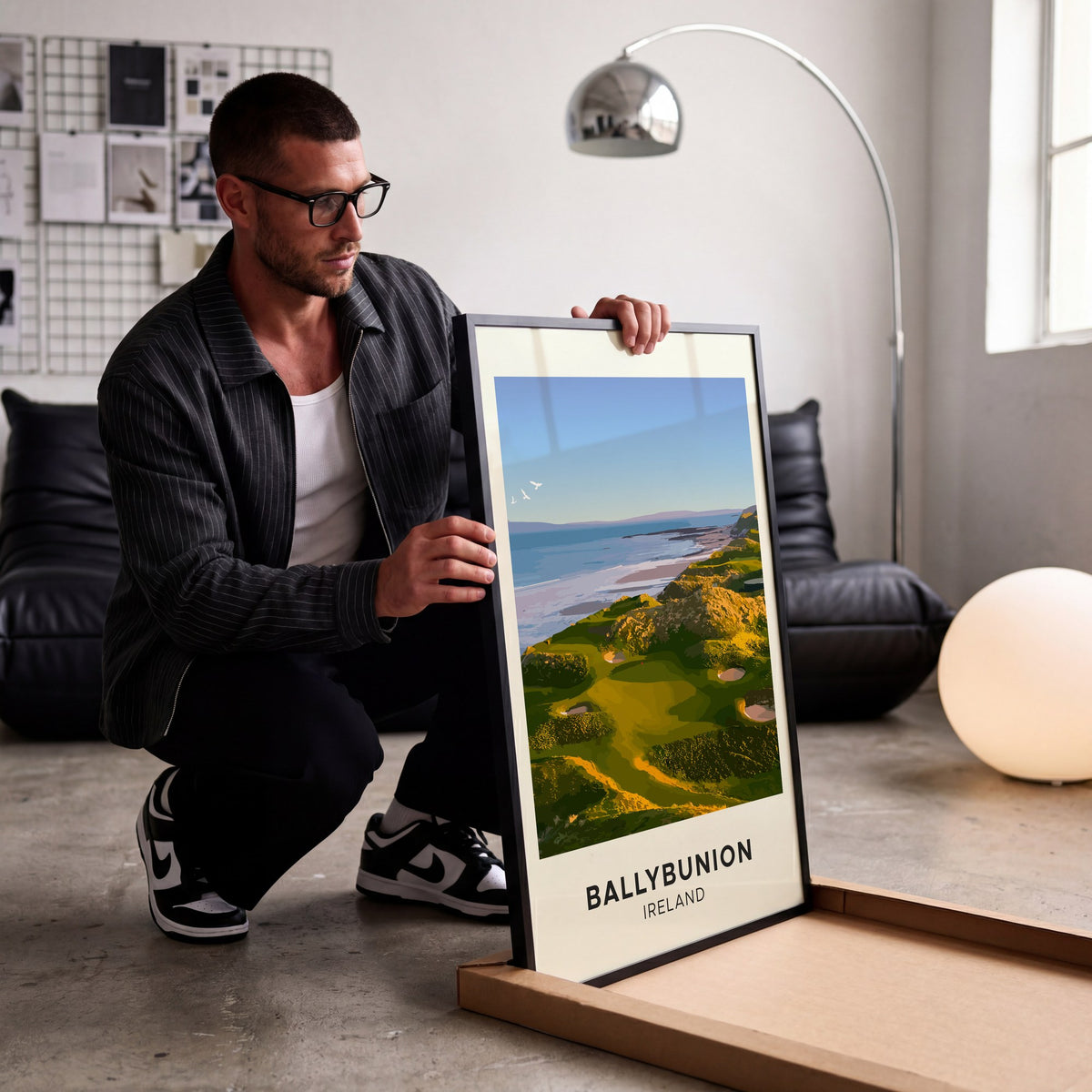 Ballybunion golf print of links greens above the sea, cream border, being unboxed in a bright studio