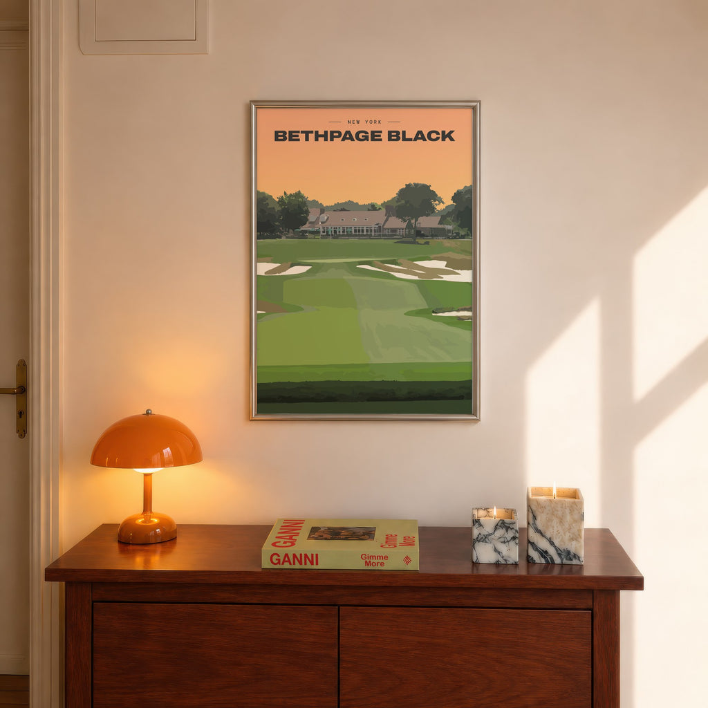 Bethpage Black golf print of a bunkered fairway up to the clubhouse, framed above a console beside an orange lamp
