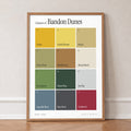 Colours of Bandon Dunes print of twelve named colour squares on white, in an oak frame, leaning against a wall on a herringbone floor