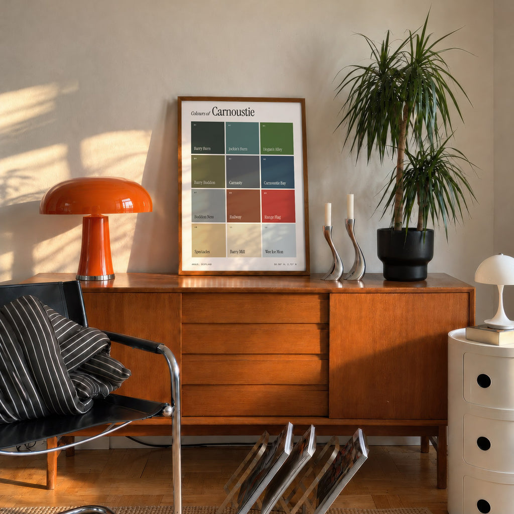 Colours of Carnoustie print of twelve named colour squares on white, framed on a mid-century sideboard beside an orange lamp