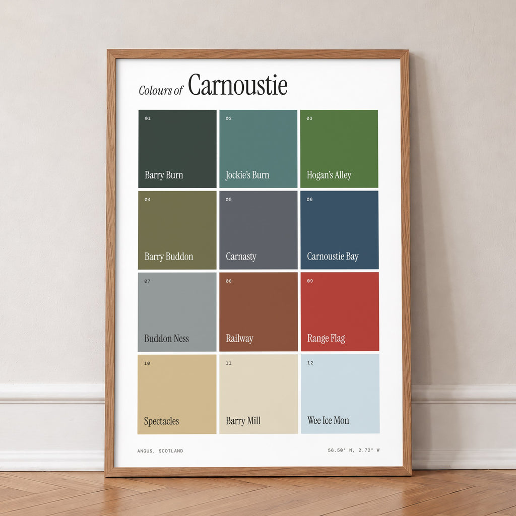 Colours of Carnoustie print of twelve named colour squares on white, in an oak frame, leaning against a wall on a herringbone floor