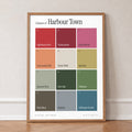 Colours of Harbour Town print of twelve named colour squares on white, in an oak frame, leaning against a wall on a herringbone floor