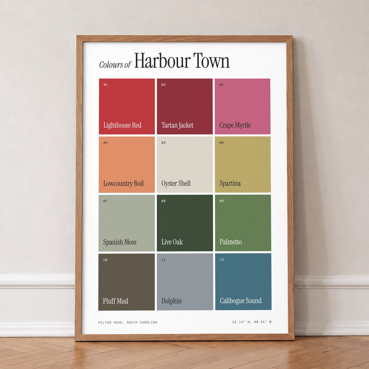 Colours of Harbour Town print of twelve named colour squares on white, in an oak frame, leaning against a wall on a herringbone floor