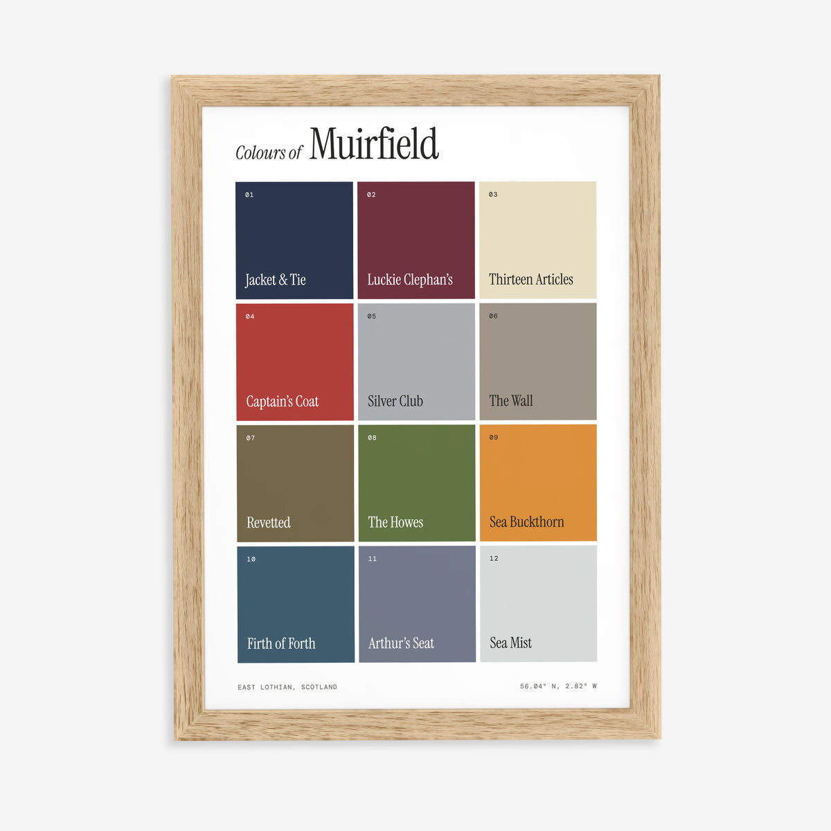 Colours of Muirfield print of twelve named colour squares on white, in a natural wood frame on a plain wall
