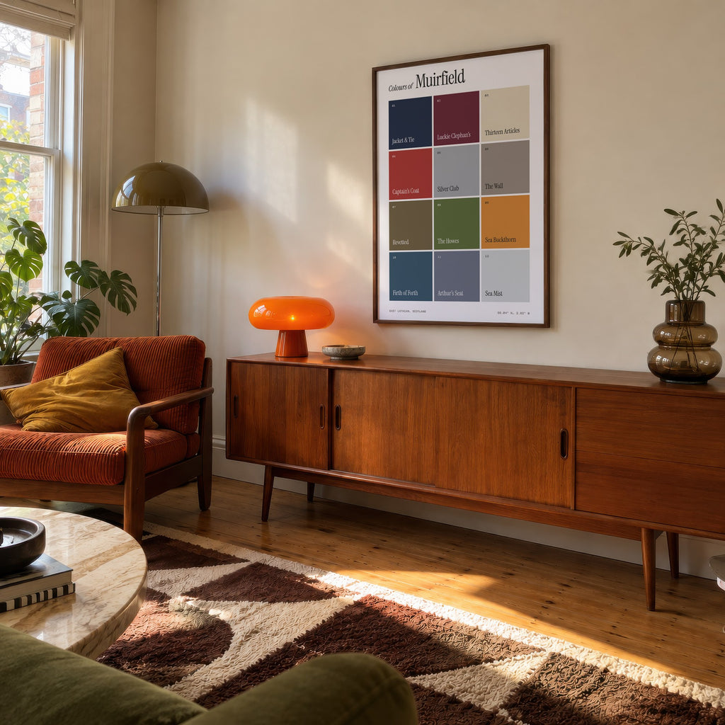 Colours of Muirfield print of twelve named colour squares on white, framed above a teak sideboard