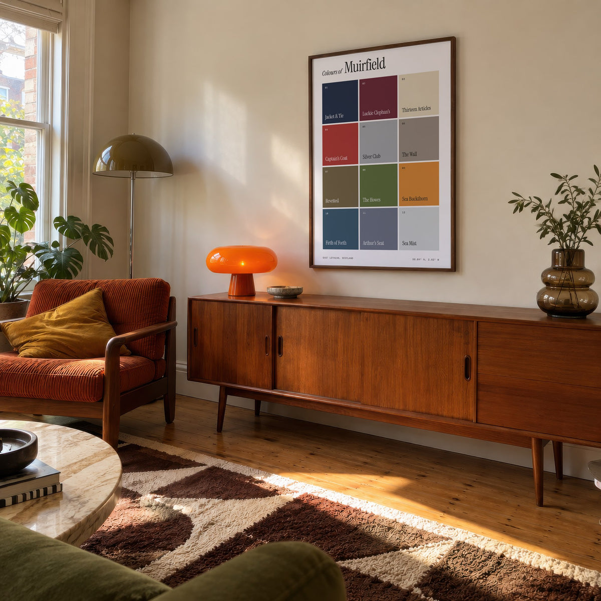 Colours of Muirfield print of twelve named colour squares on white, framed above a teak sideboard