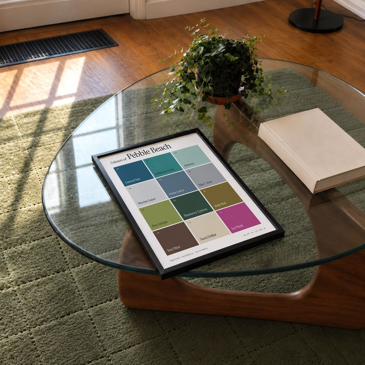 Colours of Pebble Beach print of twelve named colour squares on white, framed on a glass coffee table