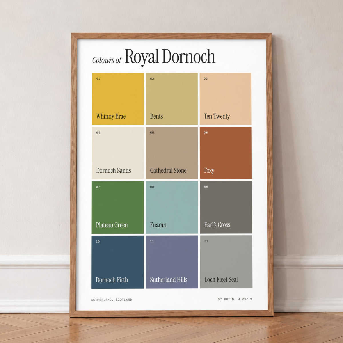 Colours of Royal Dornoch print of twelve named colour squares on white, in an oak frame, leaning against a wall on a herringbone floor