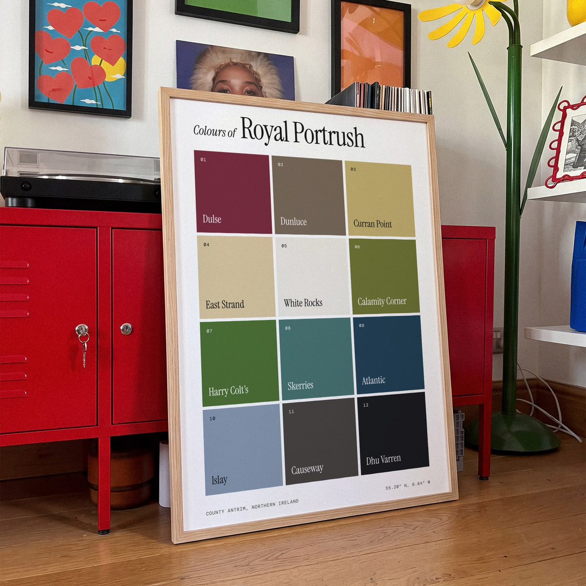 Colours of Royal Portrush print of twelve named colour squares on white, framed, leaning against red lockers