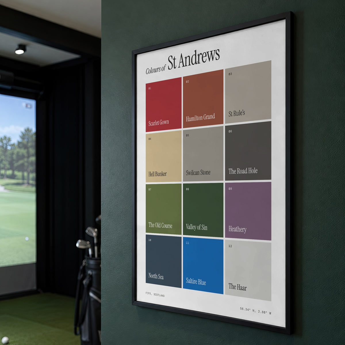 Colours of St Andrews print of twelve named colour squares on white, framed on a green wall beside a golf simulator