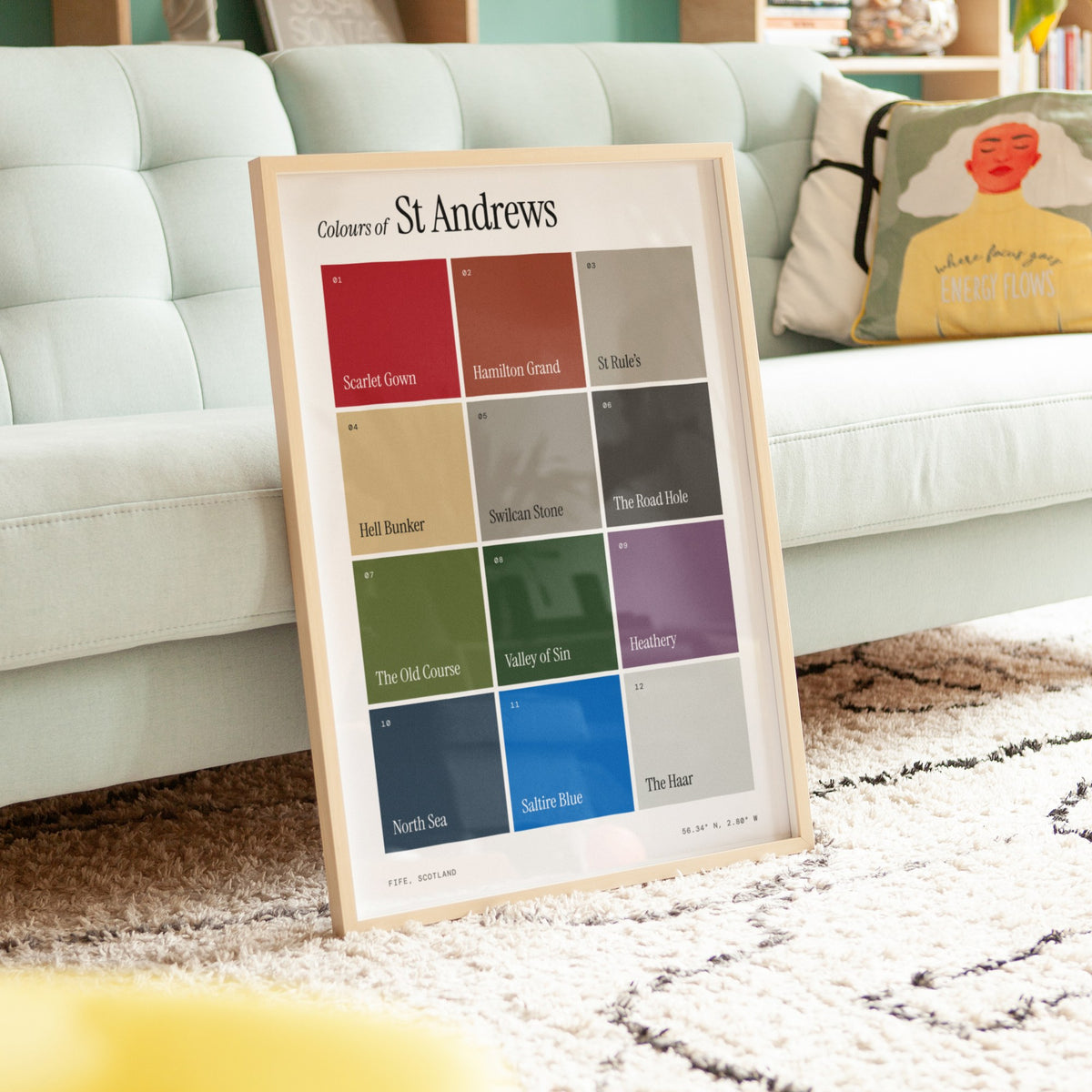 Colours of St Andrews print of twelve named colour squares on white, framed, leaning against a sofa