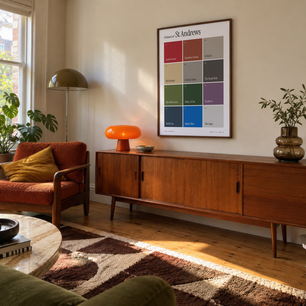Colours of St Andrews print of twelve named colour squares on white, framed above a teak sideboard