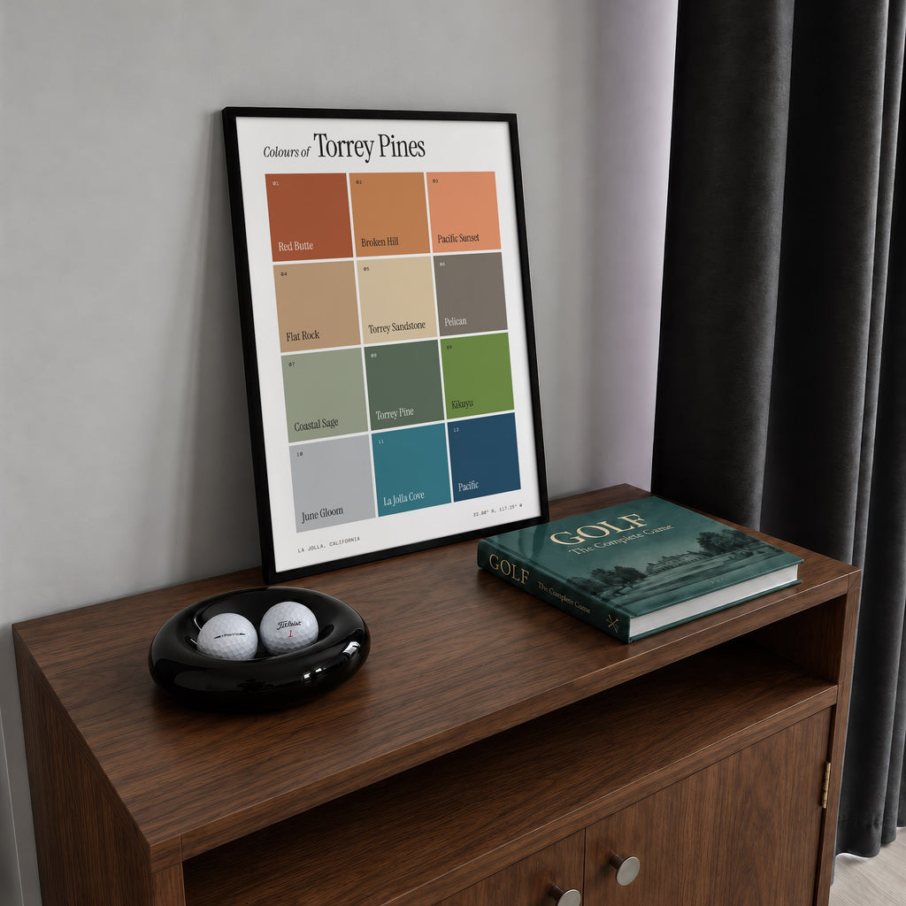 Colours of Torrey Pines print of twelve named colour squares on white, framed on a walnut cabinet beside golf balls and a golf book