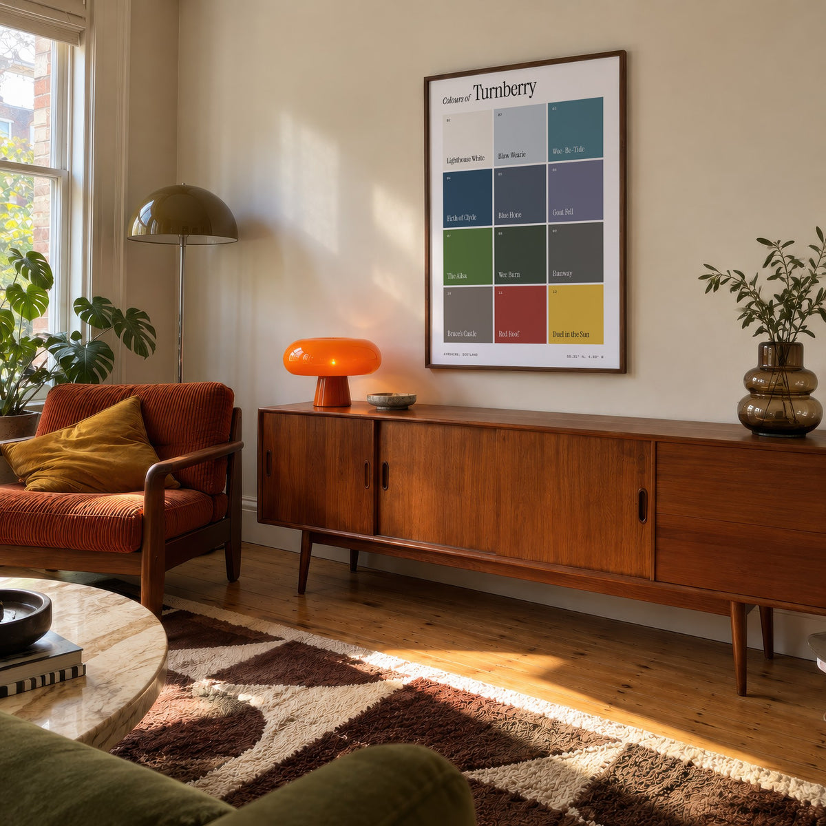 Colours of Turnberry print of twelve named colour squares on white, framed above a teak sideboard
