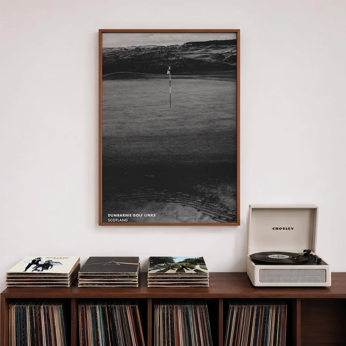 Dumbarnie golf print of a black and white photo of a flag below dunes, framed above a record shelf beside a turntable