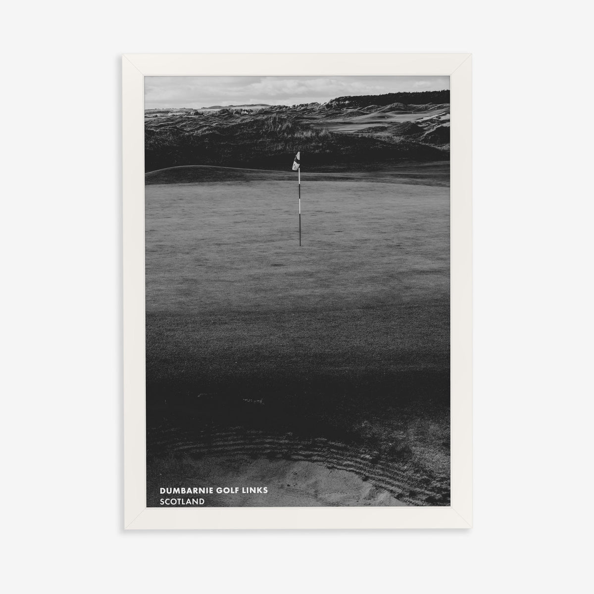 Dumbarnie golf print of a black and white photo of a flag below dunes, in a white frame on a plain wall