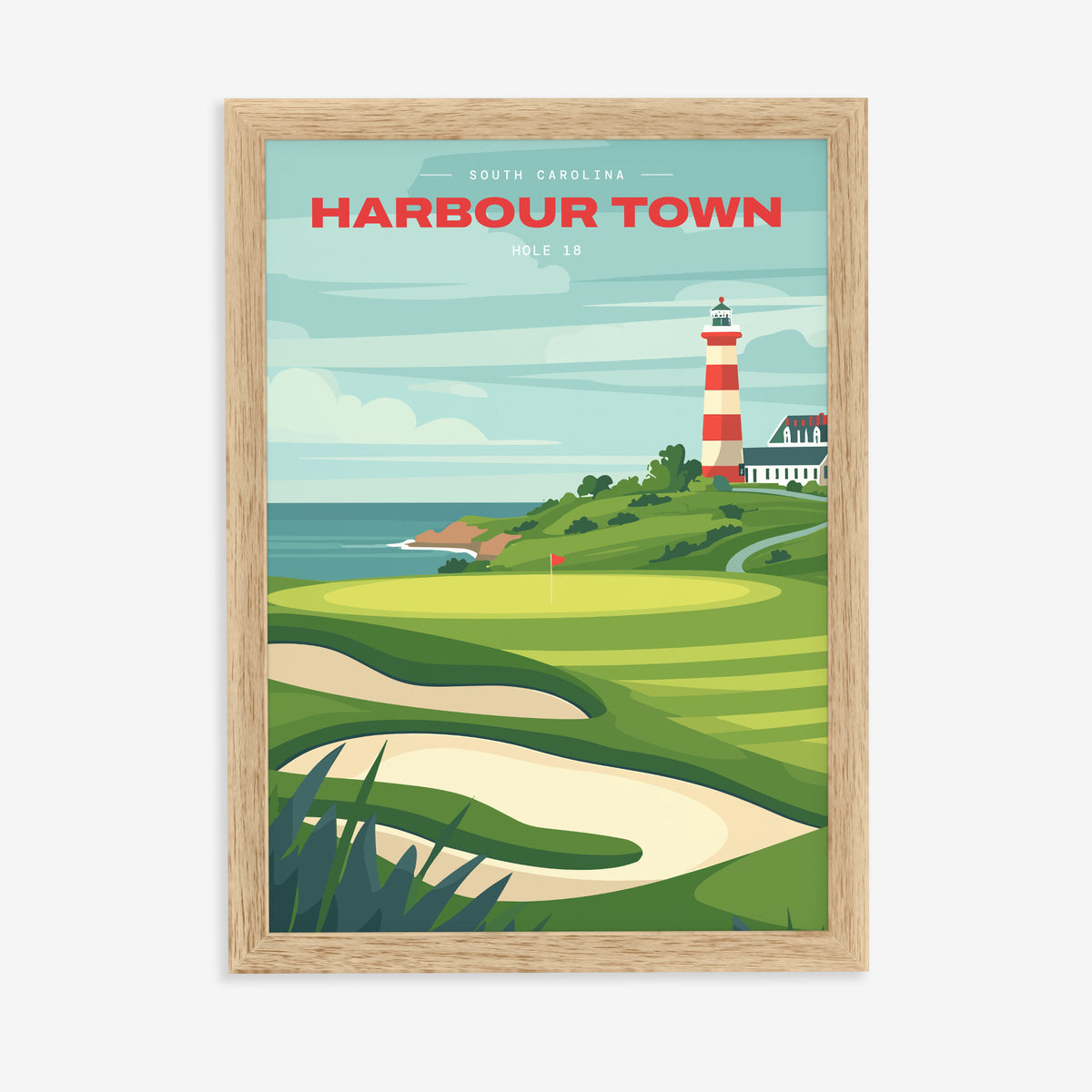 Harbour Town 18th hole golf print of a green below a striped lighthouse, in a natural wood frame on a plain wall