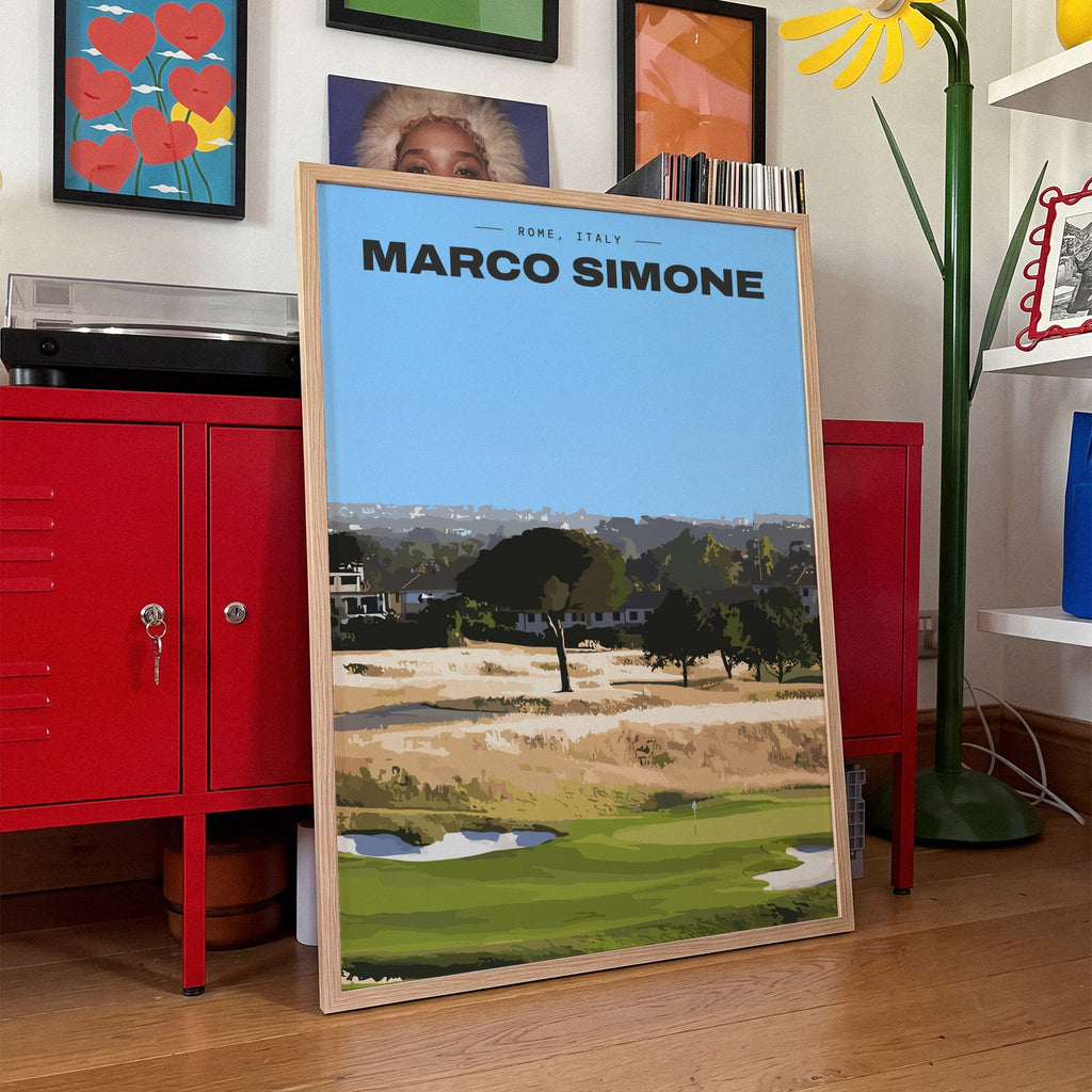 Marco Simone golf print of a green below umbrella pines and gold rough, framed, leaning against red lockers