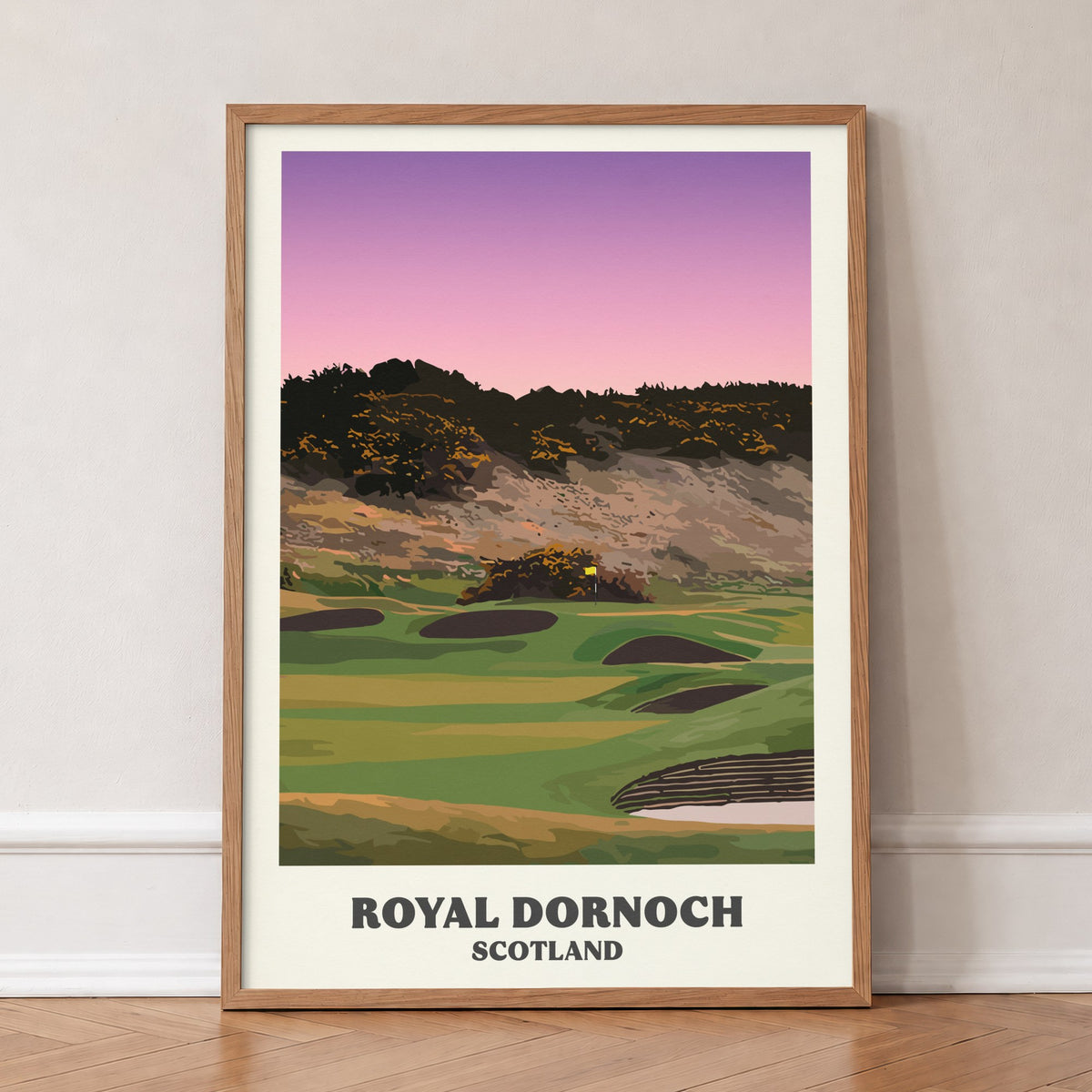 Royal Dornoch golf print of a plateau green below a gorse hill at dusk, in an oak frame, leaning against a wall on a herringbone floor