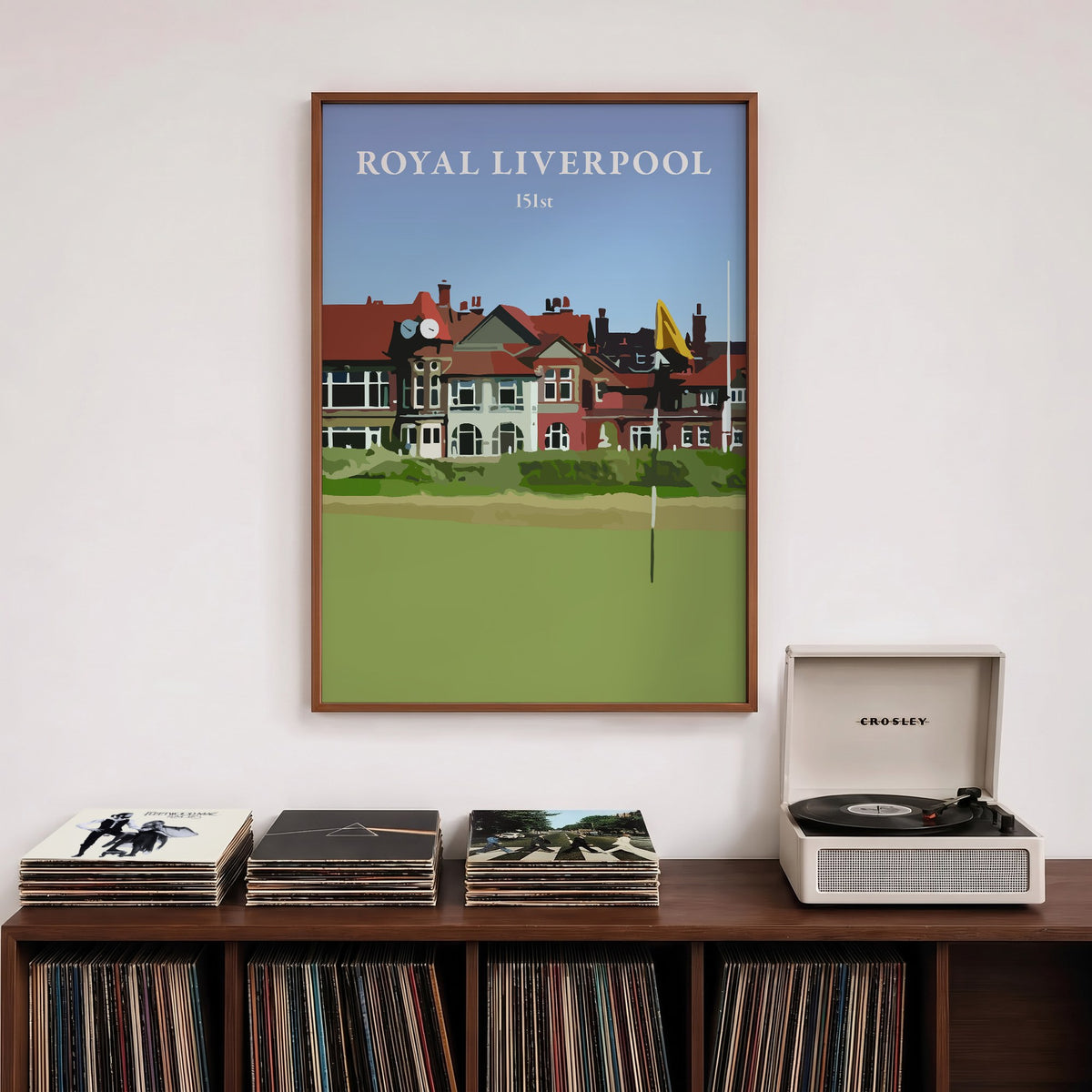 Royal Liverpool 2023 golf print of the clubhouse behind a yellow flag, framed above a record shelf beside a turntable