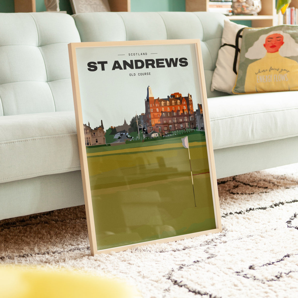 St Andrews Old Course golf print of the 18th green and flag below the town, framed, leaning against a sofa