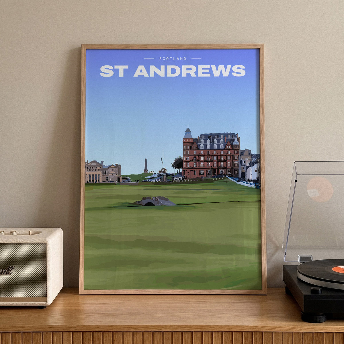 St Andrews Swilcan Bridge golf print of the Swilcan Bridge below the town, framed on a sideboard beside a record player