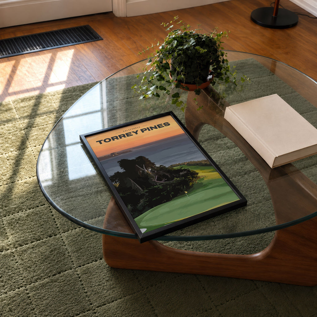 Torrey Pines golf print of a clifftop green above the Pacific at sunset, framed on a glass coffee table